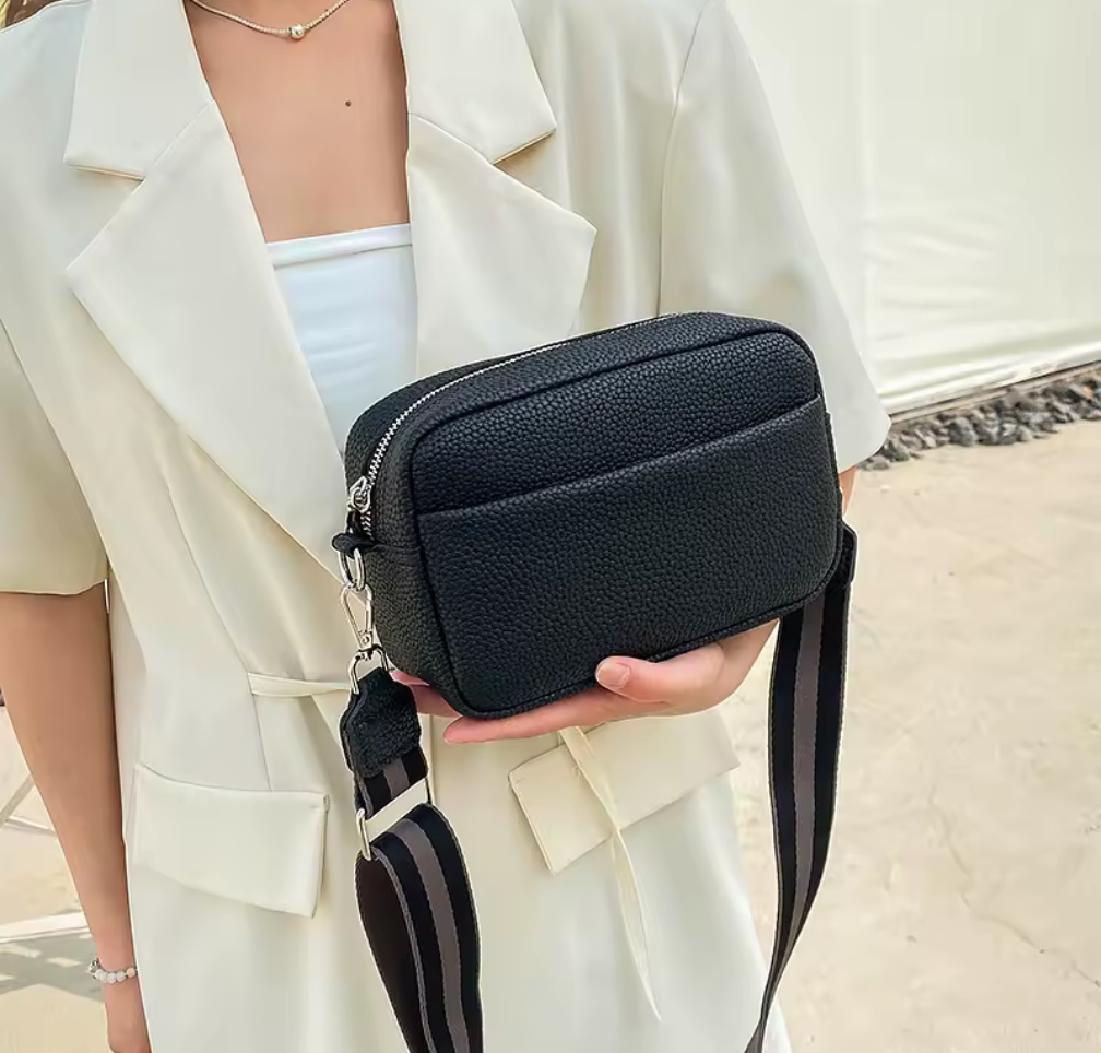 Stilren crossbody-väska med bred axelrem