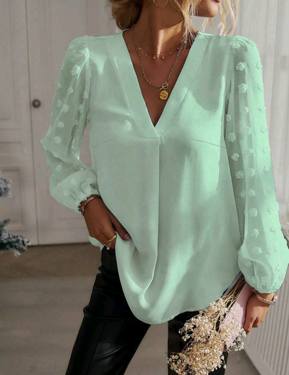 Elegant blus med transparenta ärmar och blommiga detaljer